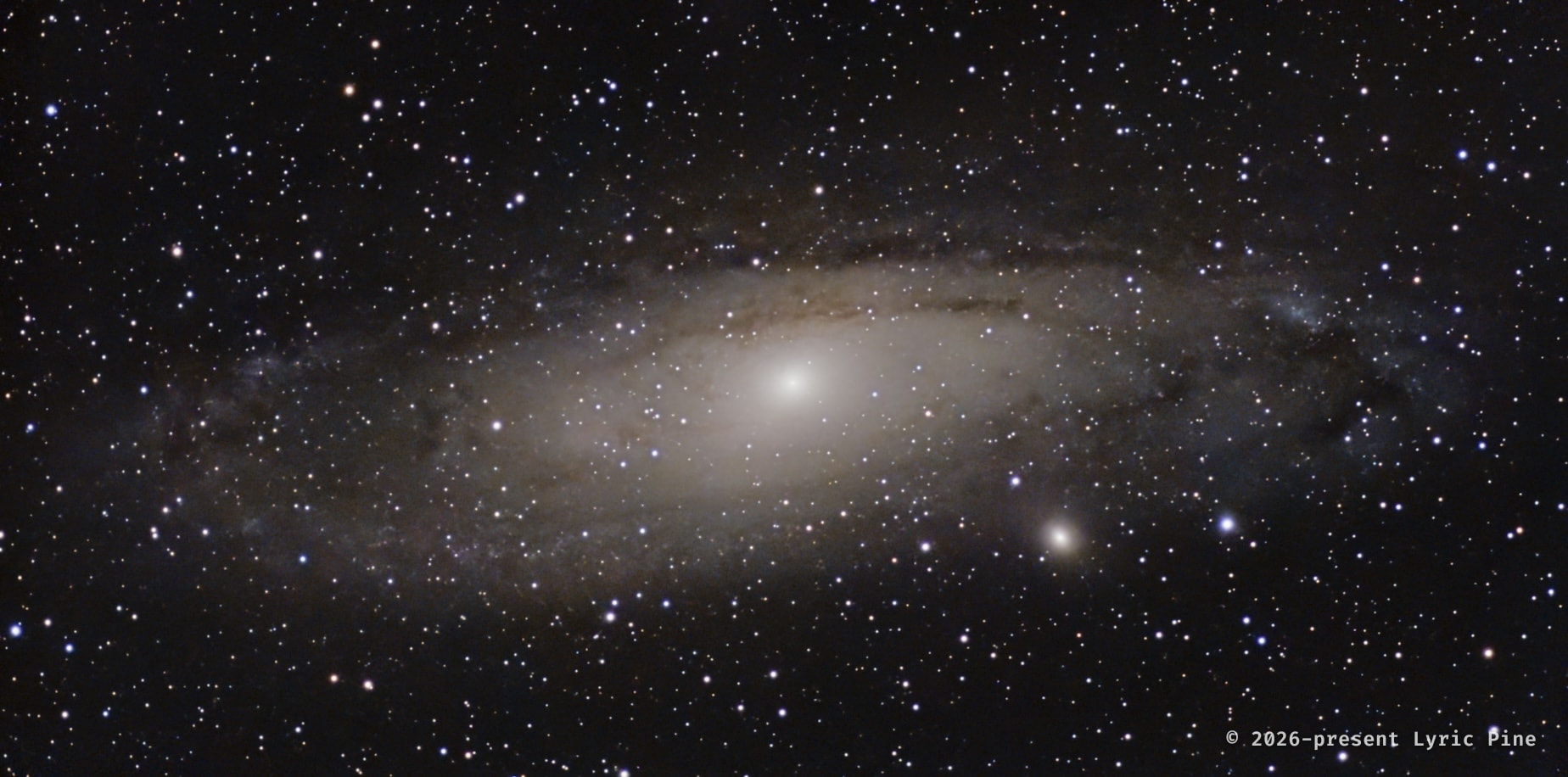 The Andromeda Galaxy (Messier 31): a bright oval core and broad spiral disk crossed by dark dust lanes amid a dense star field.