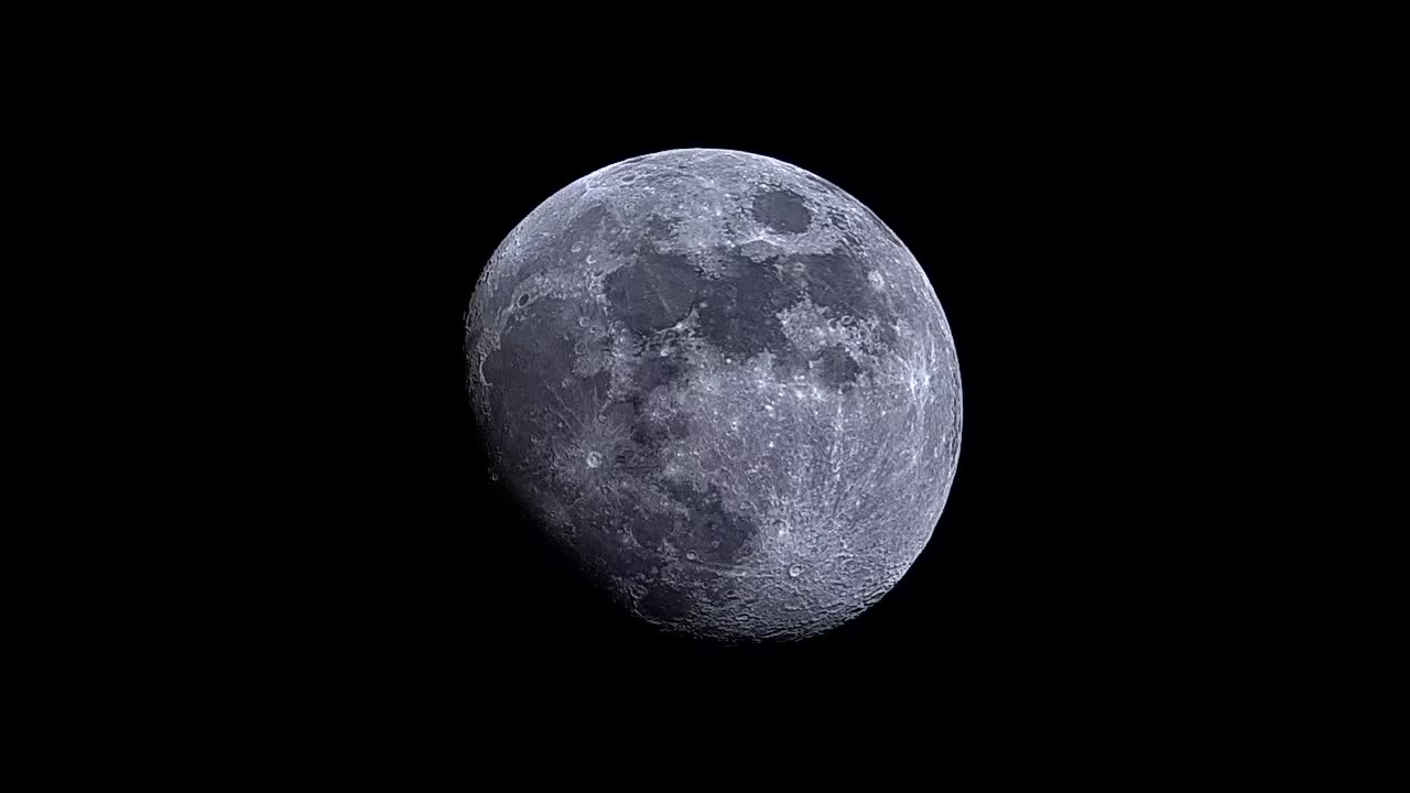 The waxing gibbous Moon filmed through a telescope, showing craters, maria, and the rugged terminator.